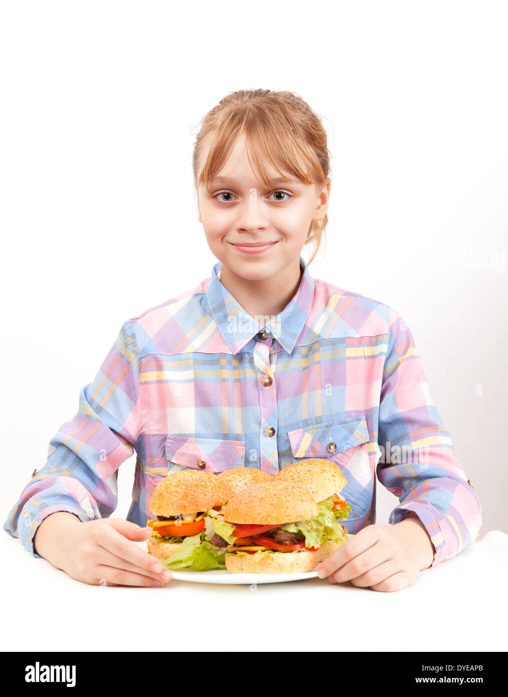 Little smiling blond girl with big homemade hamburgers on white plate Stock Photo
