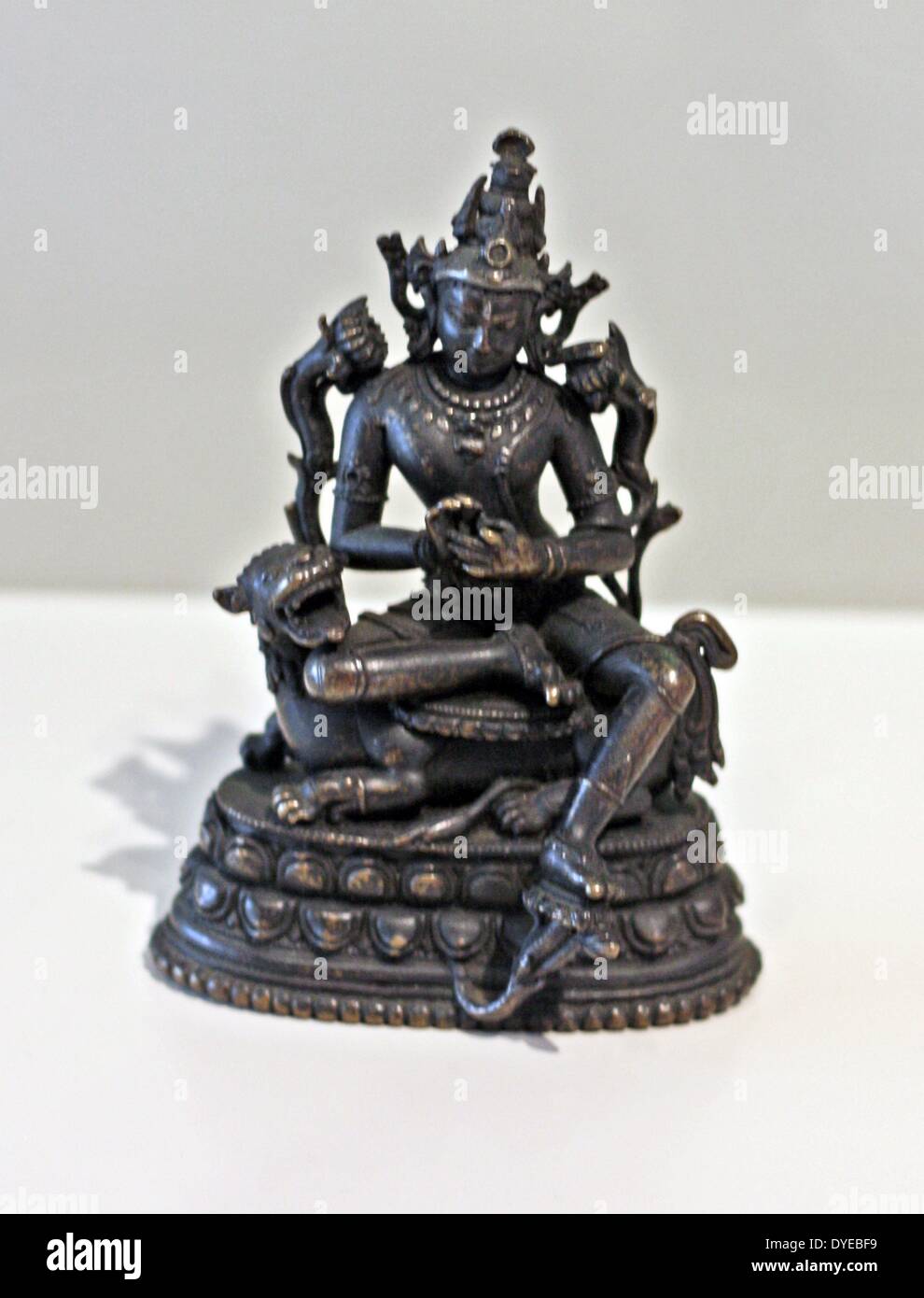The bodhisattva Manjushri. India or Bangladesh, Bengal, 11th-12th century, bronze, silver. Manjushri is seated on his mount, a lion. His relaxed pose, with one leg hanging down, is called lolita-esuna and is often found in images of bodhisattvas. On the blue water lily to the right of Manjushri's head is his attribute - the book, a symbol of wisdom. Manjushri is making the gesture to set the wheel of doctrine in motion. Stock Photo