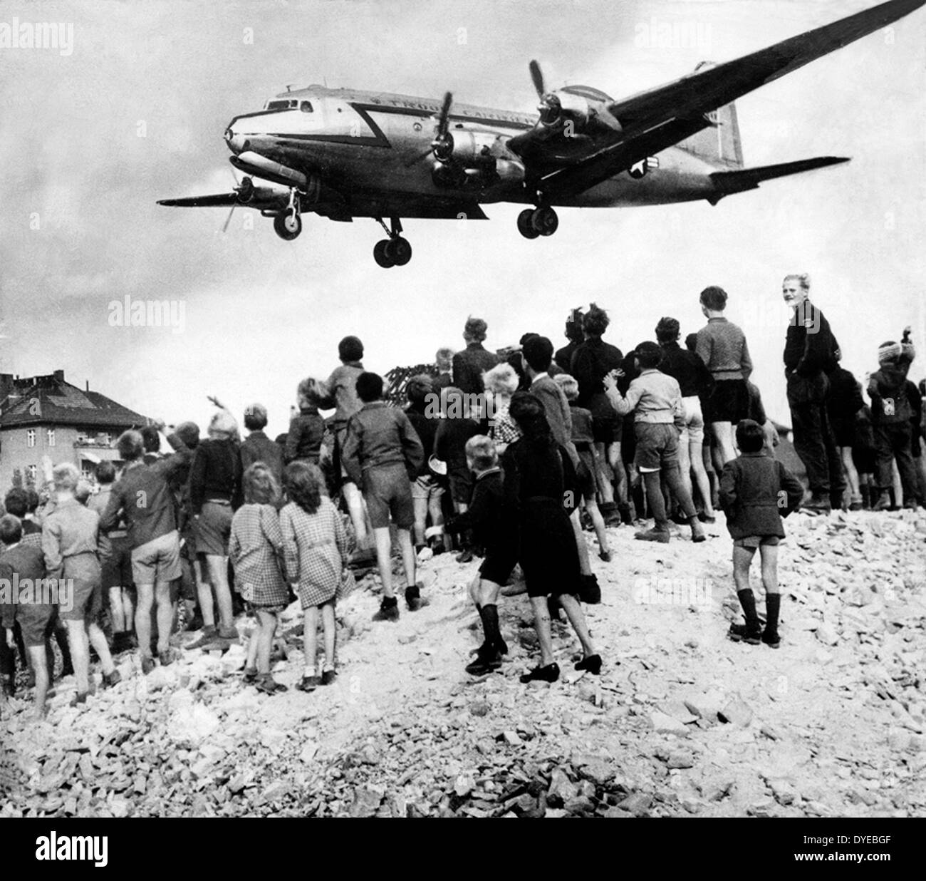 American aircraft drops food and supplies near a crowd of Berliners during the blockade of Berlin (known as the Berlin Airlift) 1948-1949. Stock Photo