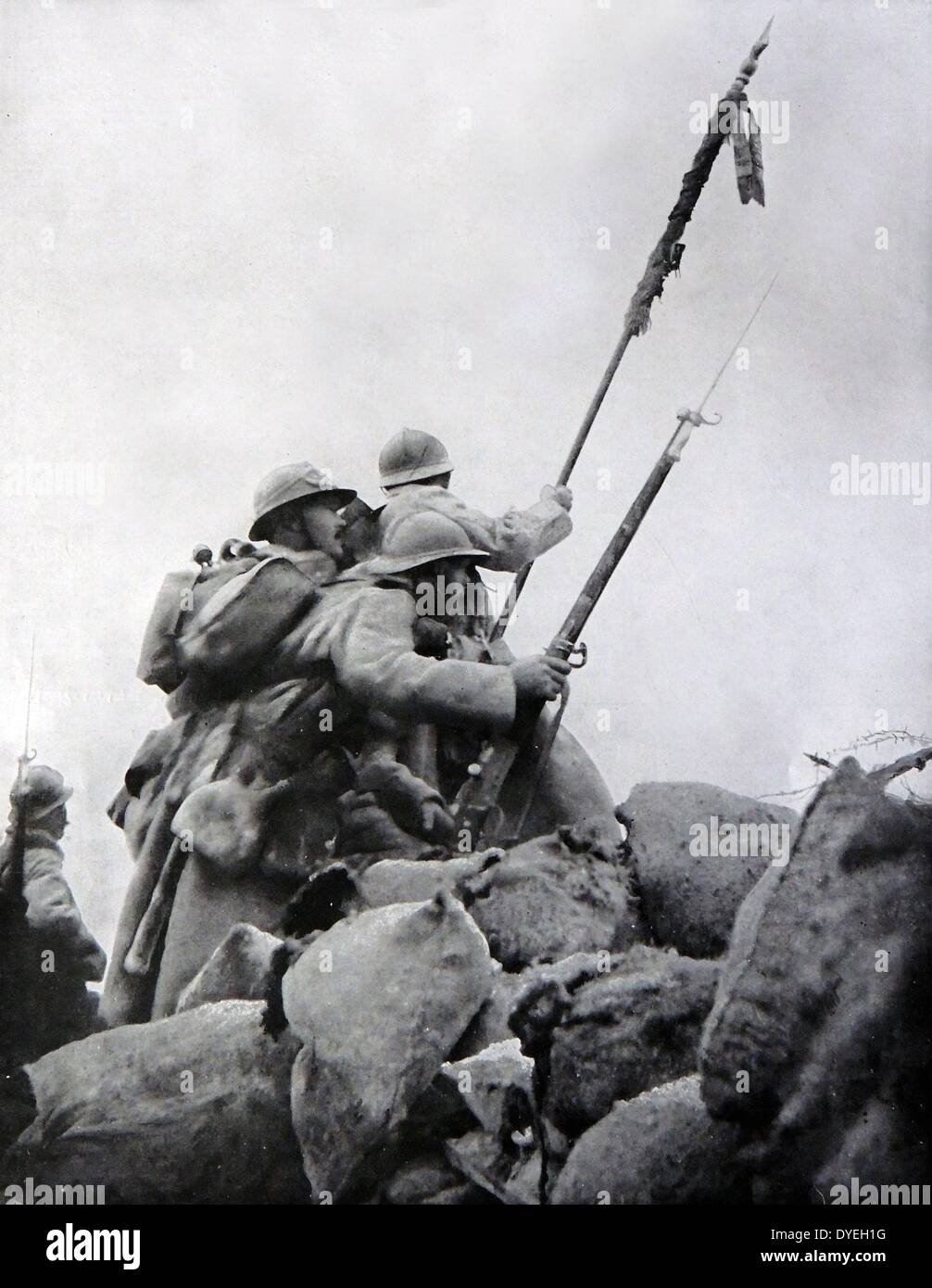 World War 1 - Heroic French soldiers rise over the top of their barricades towards the German line of fire during the First Battle of the Marne 1914. An Officer can be seen carrying a damaged regimental standard to rally the troops. Stock Photo