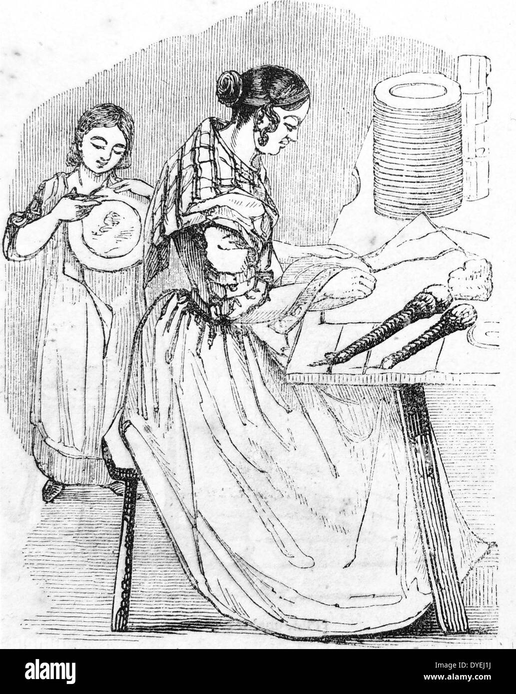 Woman and girl applying transfers to Blue Ware, the Potteries, Staffordshire, England. Transfer placed face down on plate and backing paper  rubbed with padded stick. Unglazed item absorbs the  pattern. Engraving, London, 1843. Stock Photo