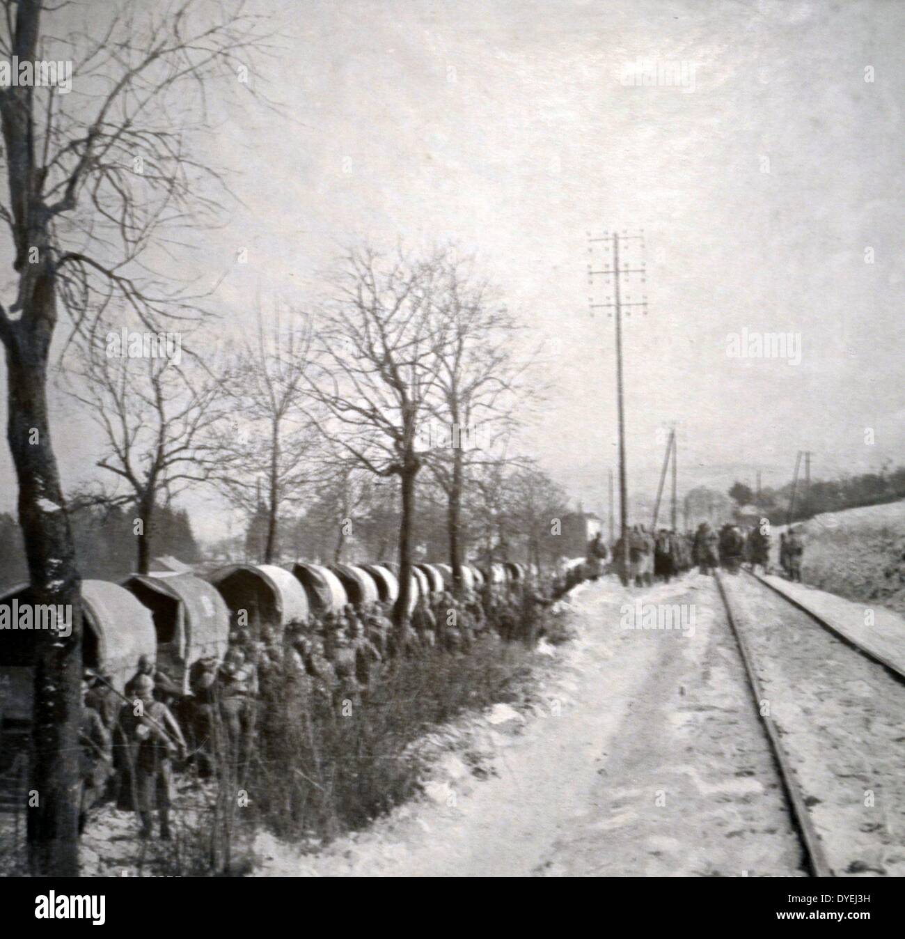 World War I - The Battle of Verdun was fought from 21 February – 18 December 1916 . Around Verdun, during the battle. On the road auto trucks are being reinforced whileon the railway track, the walking wounded are moving towards the ambulance. Stock Photo