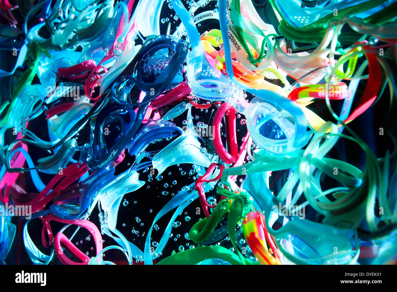 A TANGLE OF MULTI COLORED SWIMMING GOGGLES UNDER WATER WITH BLACK BACKGROUND Stock Photo