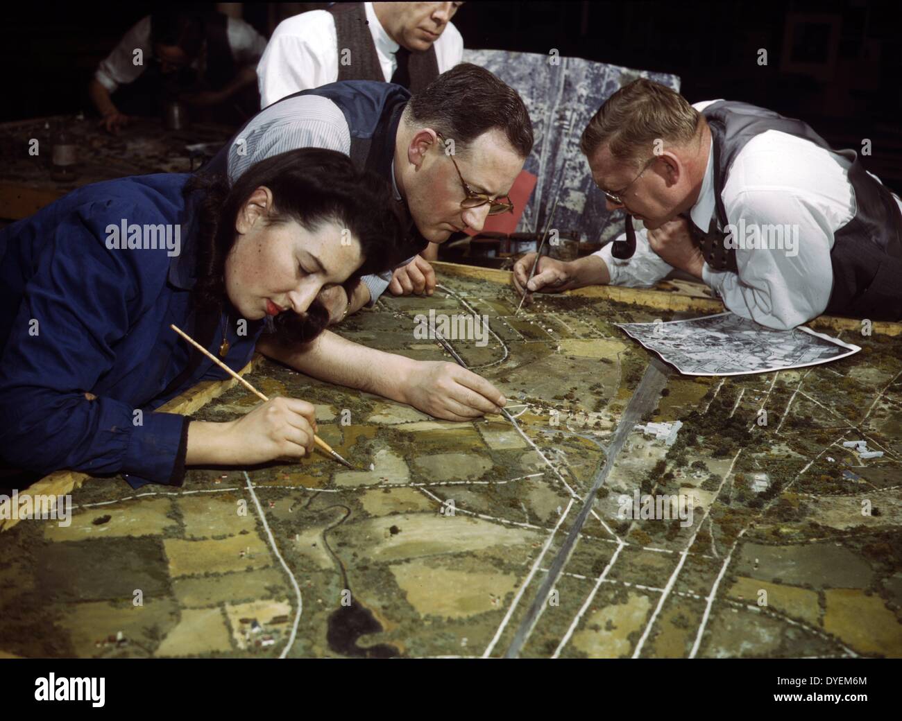 Camouflage class in New York University, where men and women training for wartime service in the US Army, New York, N.Y. They make models from aerial photographs, photograph them, then work out a camouflage scheme and make a final photograph. 1943 Stock Photo