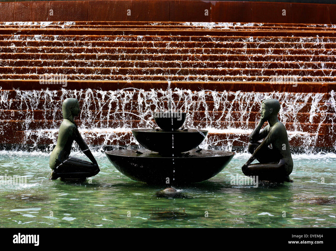 Fountain in Victoria Square, Birmingham, England.  statues and fountain represent youth . This bronze sculpture,  is 1.5 m (5 ft) tall and 1.5 m (5 ft) in diameter. It depicts a boy and a girl facing each other at either ends of a fountain. Beside them are an egg and a cone Stock Photo