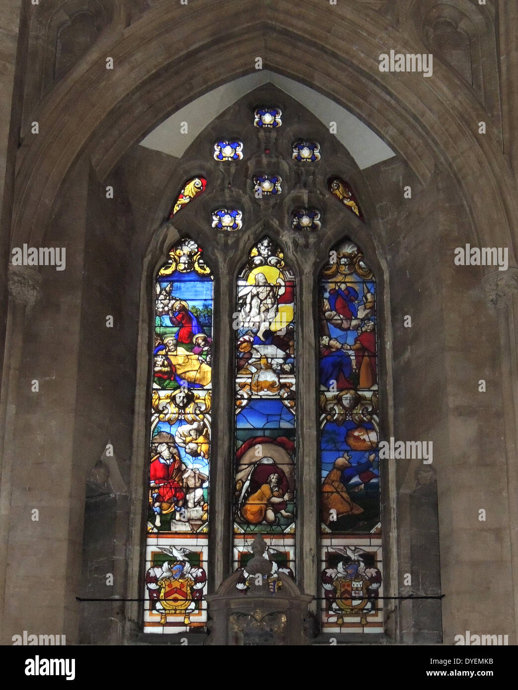 The Glemham window, stained glass window at Bristol Cathedral, England. This window was one of a pair; the other formerly to be found on the south side but of which only fragments remain after the 1940 bombing. It depicts various episodes from the bible including: Gethsemane, The Resurrection, The Transfiguration, Abraham & Isaac, Jonah swallowed by the whale, Elijah ascending to heaven in a chariot and at the bottom the Coats of arms of the Glemham family and their alliances. Stock Photo