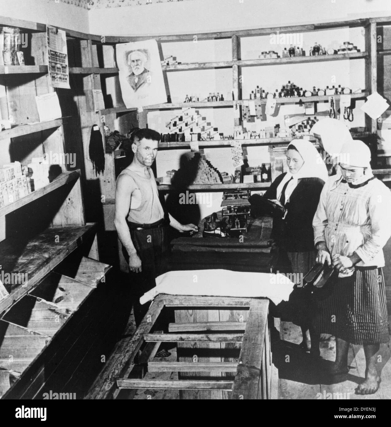 Shoes are scarce in 'workers paradise' 1951. Photograph showing Soviet women in a Russian store looking at shoes. Soviet farm women in the Ukraine look at a consignment of over-shoes just received at the village store. Such shipments are scarce and are eagerly awaited. Notice the empty bins and shelves in the foreground. Stock Photo