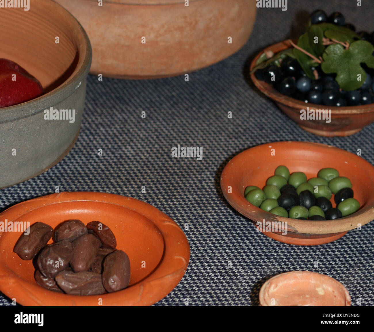 Models depicting typical Roman food from the early part of the Roman Empire. Nuts, grapes and olives are shown in simple clay dishes Stock Photo