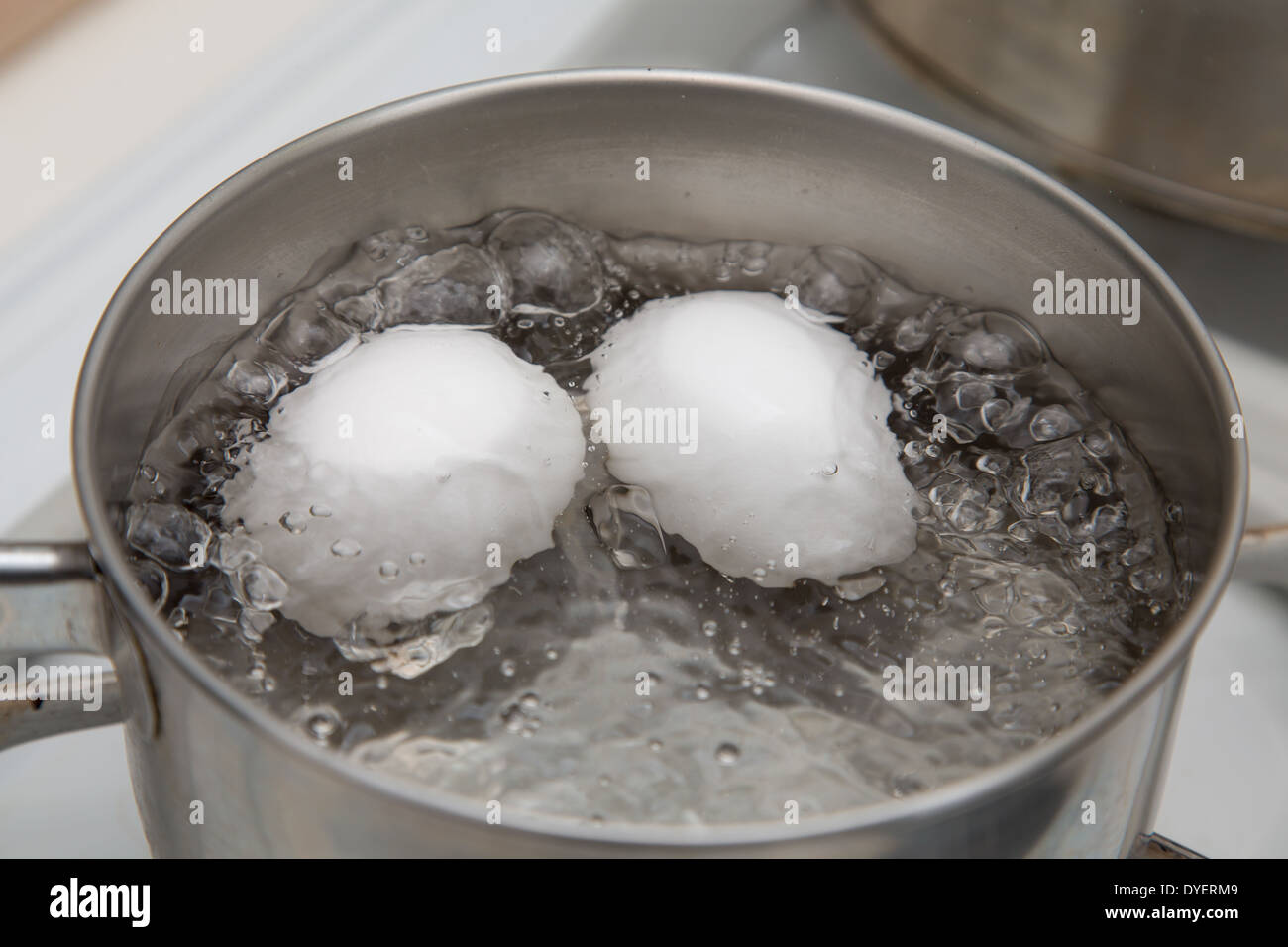 Two eggs boiling in pan of water Stock Photo Alamy