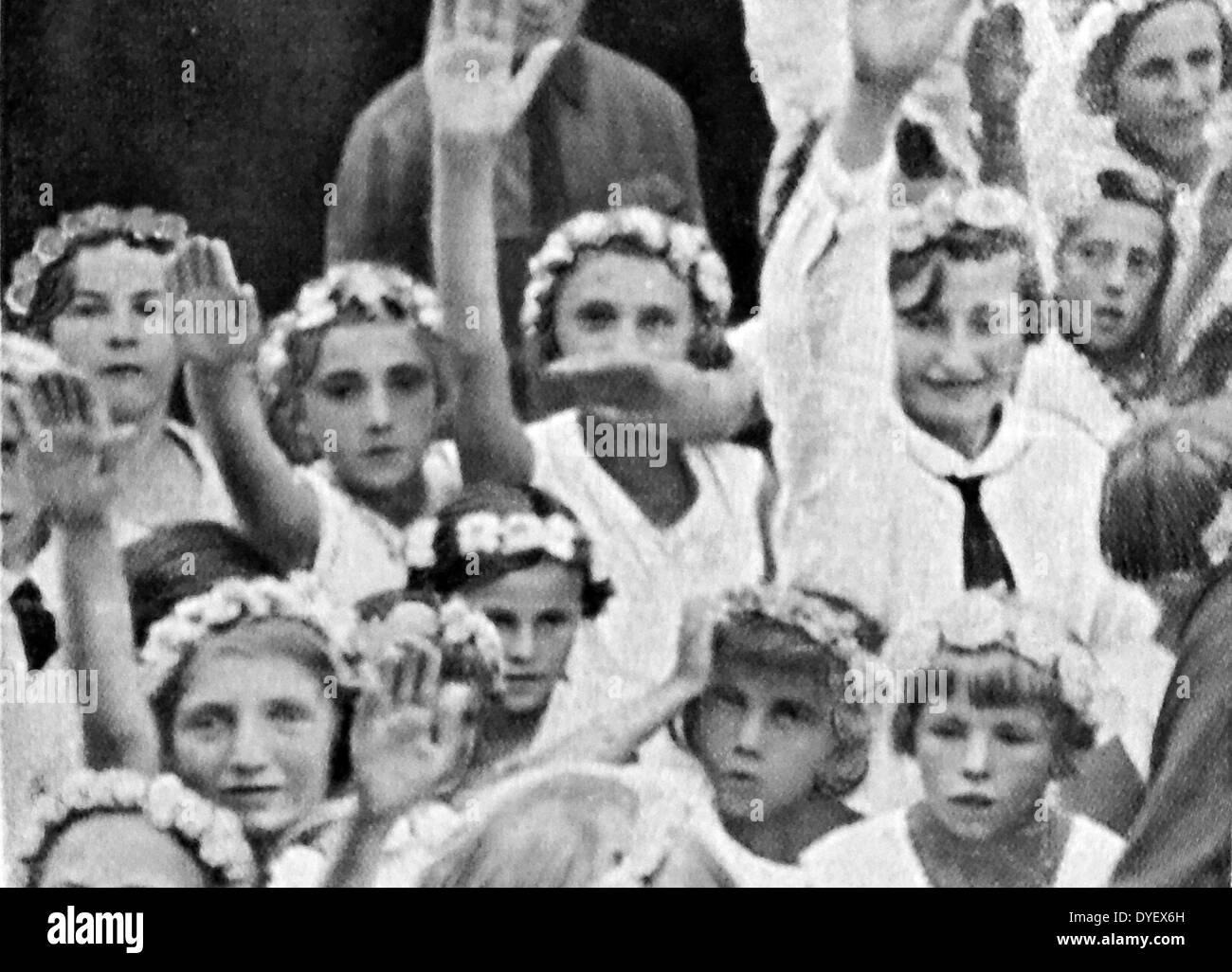 adoring supporters of Hitler await the arrival of Adolf Hitler at a rally. These photographs were taken to enhance the father of the nation status of Adolf Hitler after he became Chancellor of Germany in 1933.Young children were chosen to re-inforce the Aryan ideal of racial purity Stock Photo
