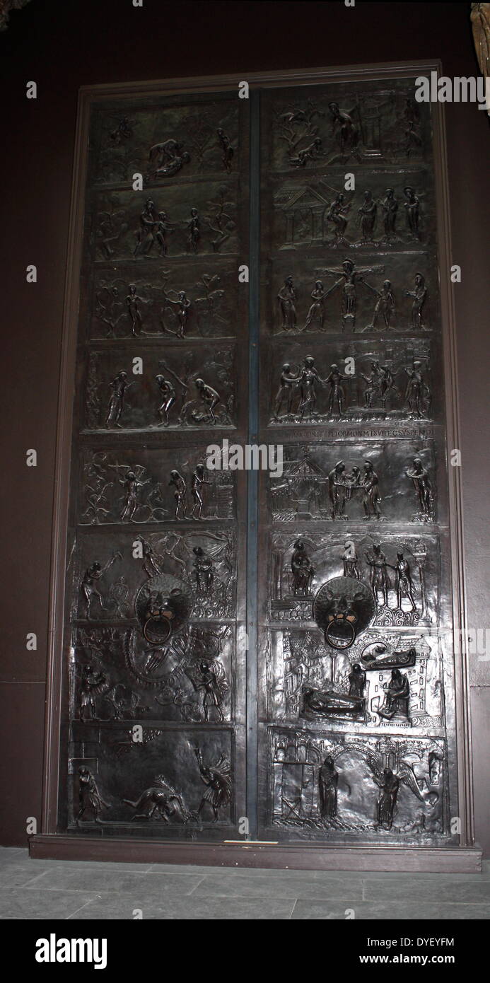 Bronze doors with scenes from the Old and New Testament in relief. Made at the order of St. Bernward, and set up by him in 1015 at St. Michael's Church, Hildesheim. The left side shows the Creation of Eve, the Presentation of Eve to Adam, the Temptation, the Fall, The Expulsion, the Labours of Adam and Eve, the Sacrifice of Abel and Cain, the Murder of Abel. The right side shows the Annunciation, the Nativity, the Adoration of the Magi, the Presentation to Simeon, Christ before Pilate, the Crucifixion, the Maries at the Sepulchre, and Christ appearing to St. Mary Magdelen. Stock Photo