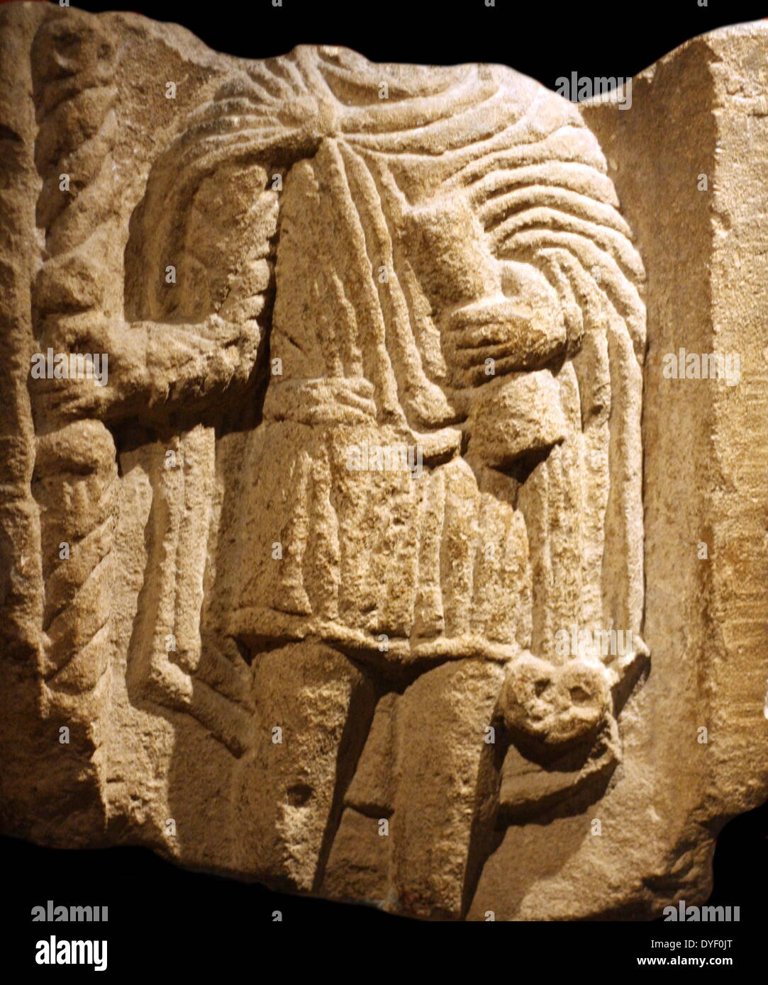 Relief image of a learned man, found in the Roman Baths. Circa 1st-3rd century AD. Shown holding a scroll indicating he is educated. The head is missing from deterioration. Stock Photo