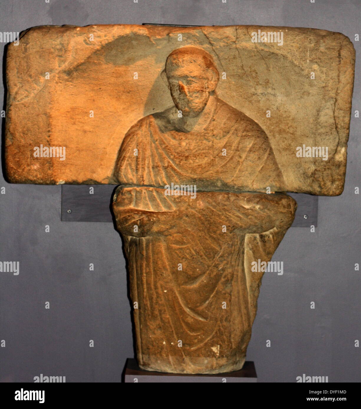 The gravestone of a man from Aquae Sulis. The tombstone is a relief image showing him how he wished to be remembered. With a scroll, reflecting his learning and status. It was re-used in the medieval town wall. Circa 1st-3rd century AD. Roman. Stock Photo