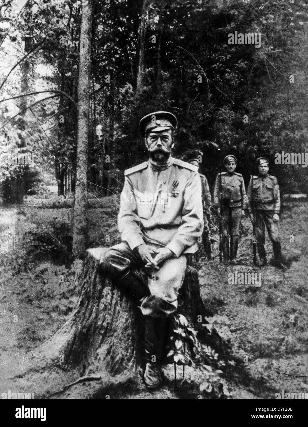 A photograph of Tsar Nicholas II, the last Emperor of Russia, Grand Duke of Finland, and King of Poland. Shown here sat outdoors on the stump of a felled tree. Stock Photo