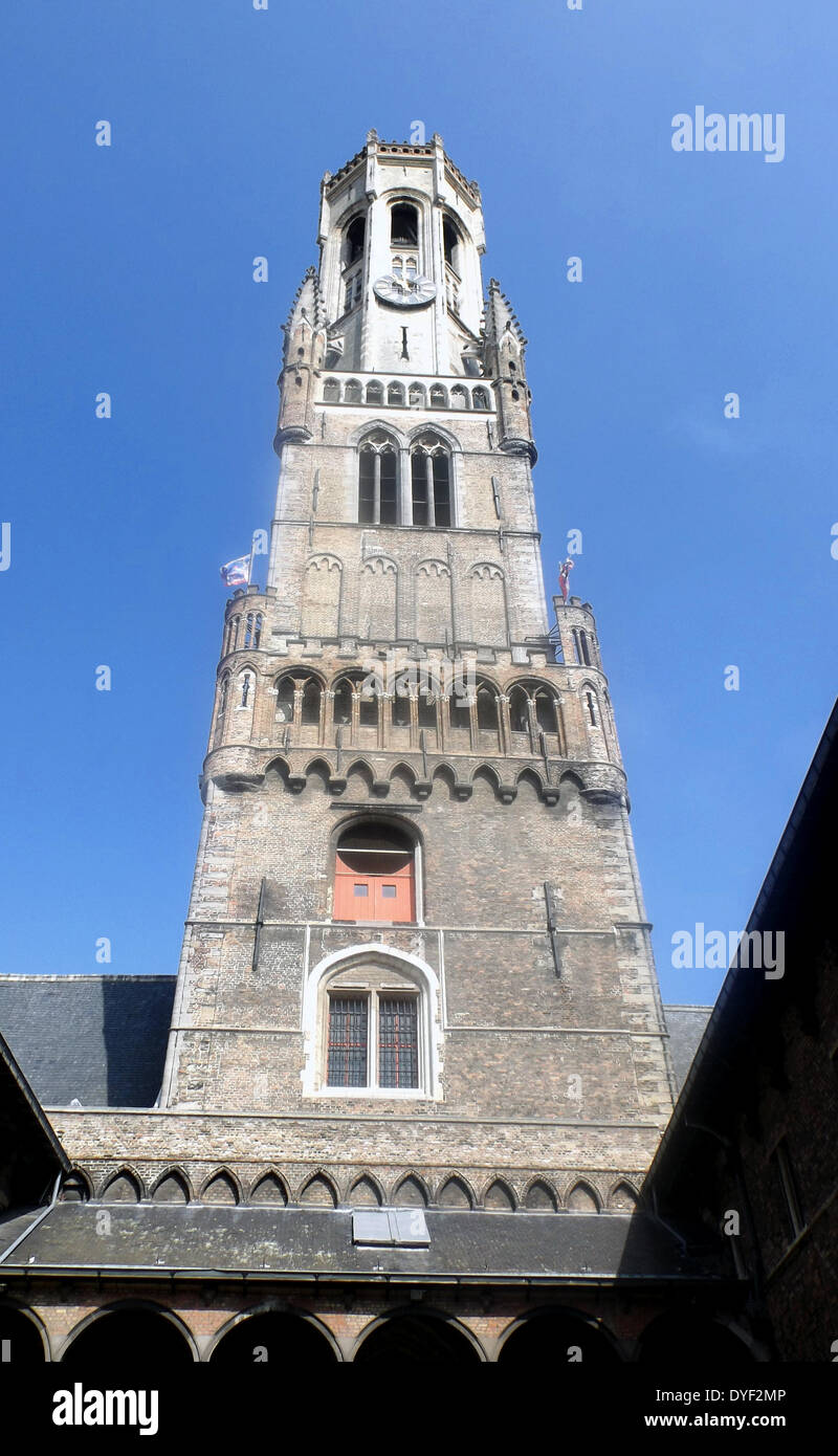 The belfry of Bruges, or Belfort, is a medieval bell tower in the historical centre of Bruges, Belgium. One of the city's most prominent symbols, the belfry formerly housed a treasury and the municipal archives, and served as an observation post for spotting fires and other danger. A narrow, steep staircase of 366 steps, accessible by the public for an entry fee, leads to the top of the 83-metre-high building, which leans about a metre to the east. Stock Photo