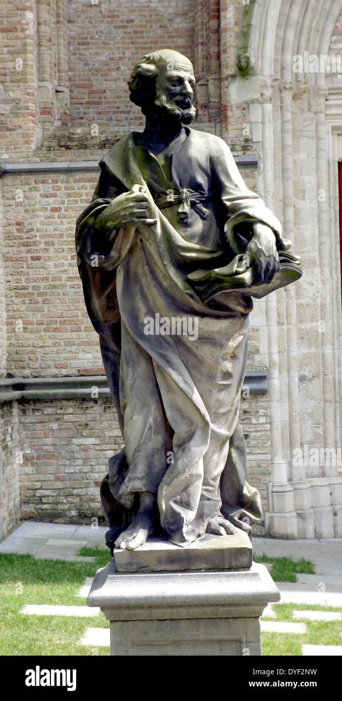Statue of a saint, in the grounds of the The Sint-Salvator Cathedral, (Saint Saviour), is the main church of the city of Bruges in Belgium. The oldest surviving part, dated from the 12th century, formed the base of the mighty tower. Stock Photo