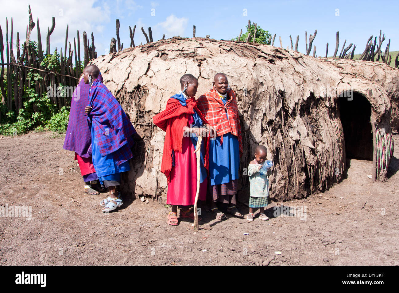 Maasai Women in traditional clothes outside of their hut Photographed in Kenya Stock Photo