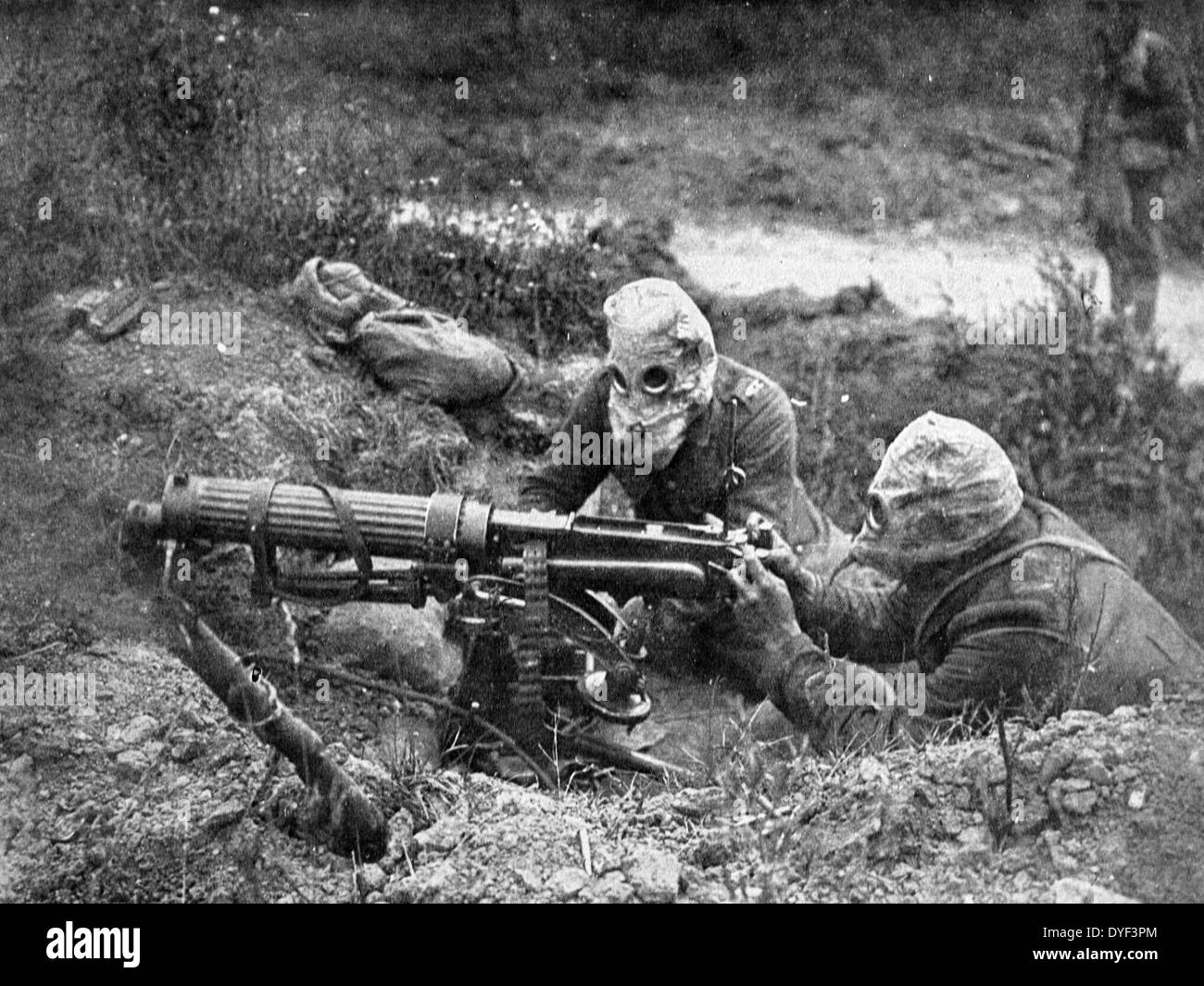 Photograph showing the Vickers Machine Gun being used during the First World War. Two soldiers handle the gun while wearing protective headgear. Circa 1914-1918. Stock Photo