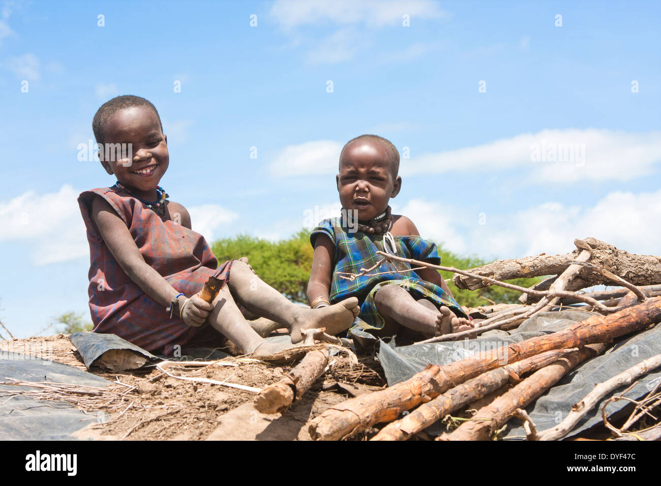 2 Maasai children on the roof of a hut. Photographed in Kenya Stock Photo