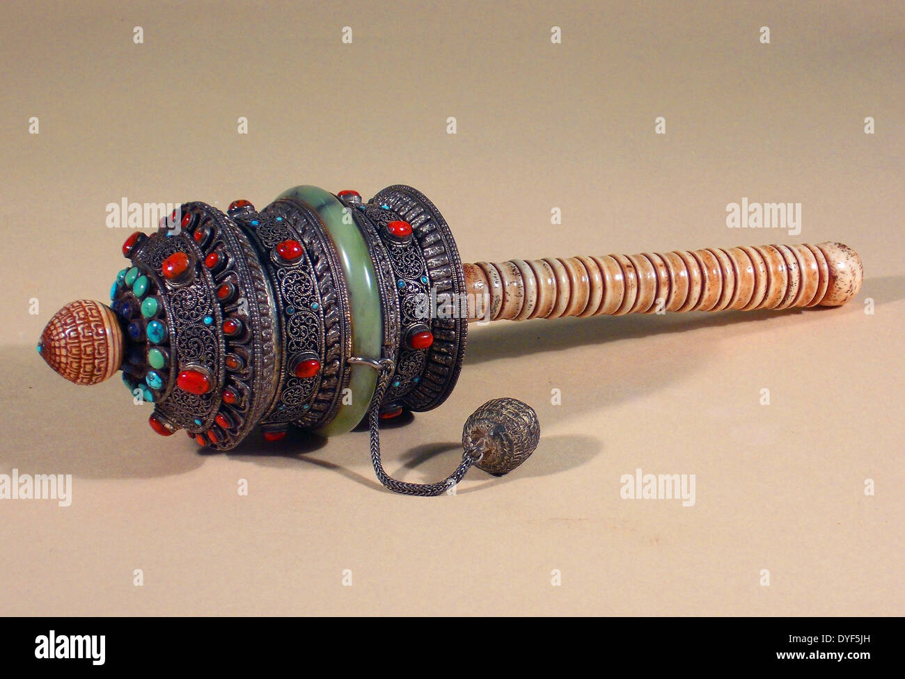 Ancient Tibet: Hand-held prayer-wheel; carved bone, Tibetan silver, coral and turquoise. Stock Photo