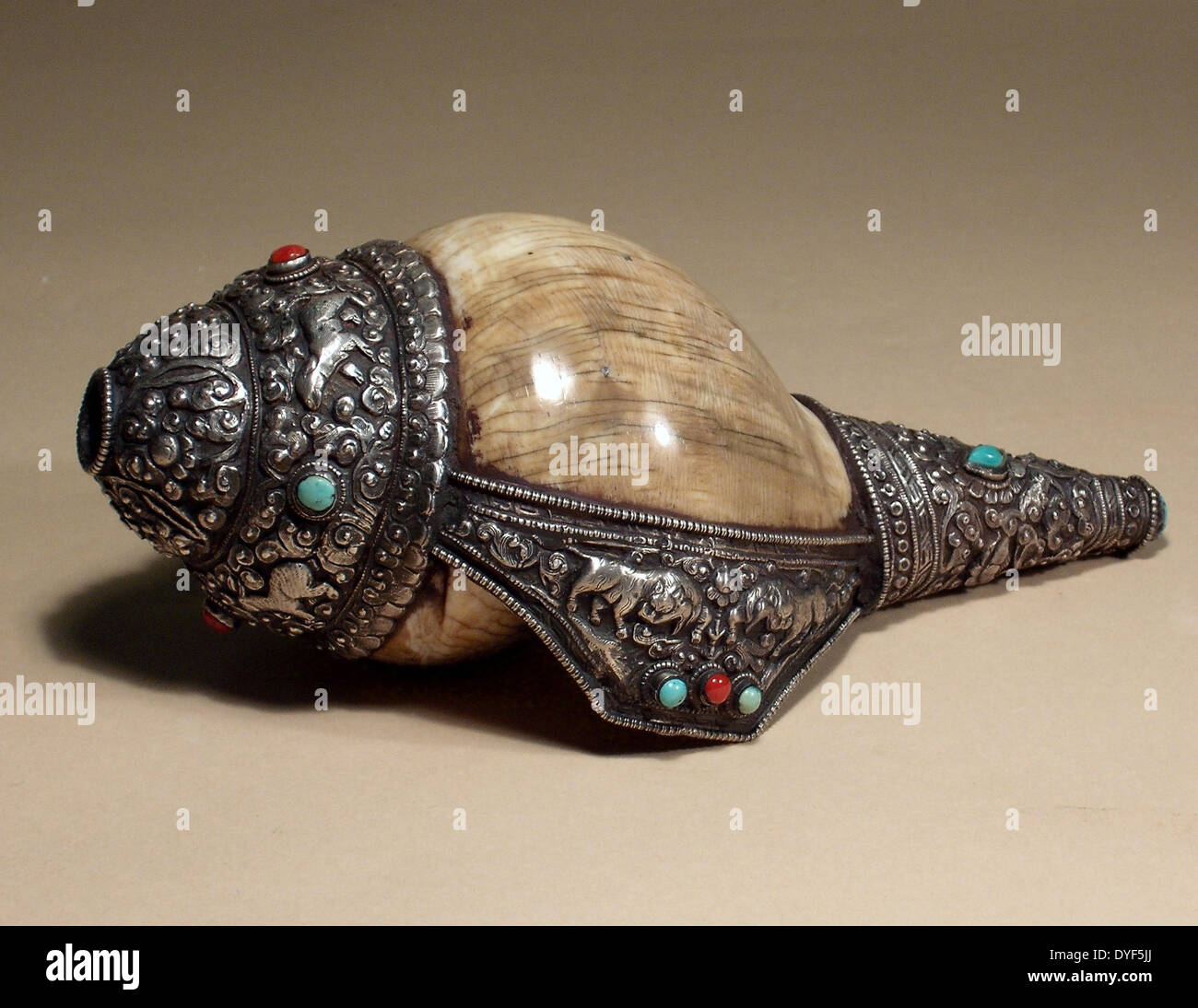 Tibet: Conch shell trumpet.  Conch shell deorated with Tibetan silver, coral and turqiouse, wth animal motifs. Stock Photo