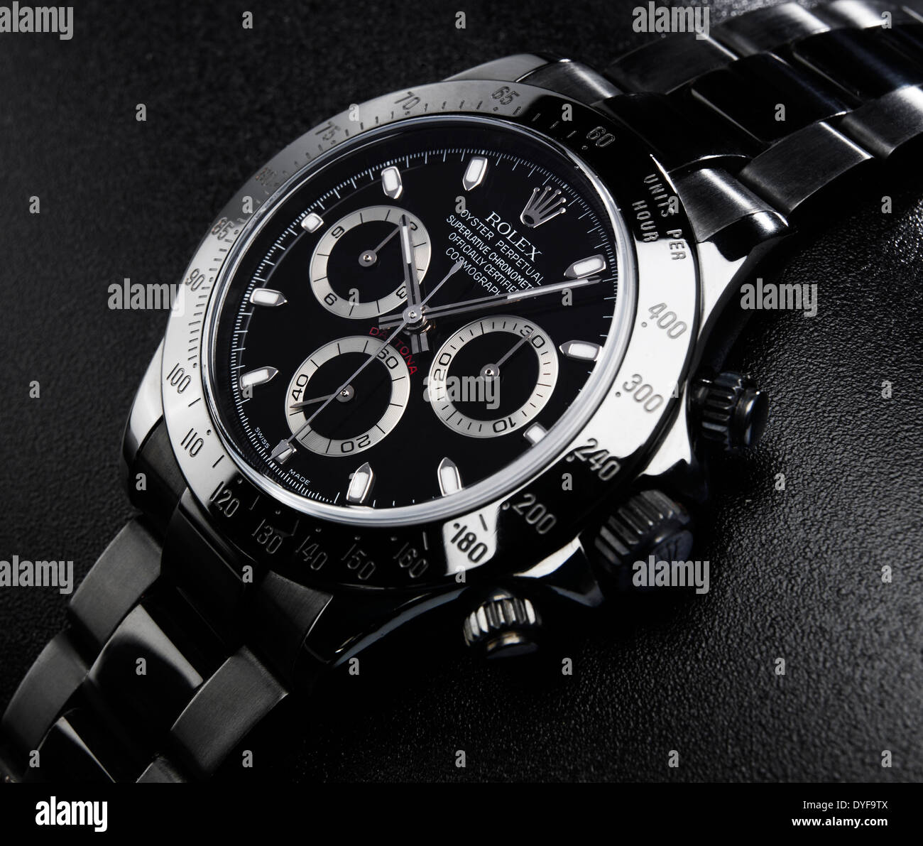AN EXPENSIVE METAL ROLEX WATCH ON A BLACK BACKGROUND Stock Photo