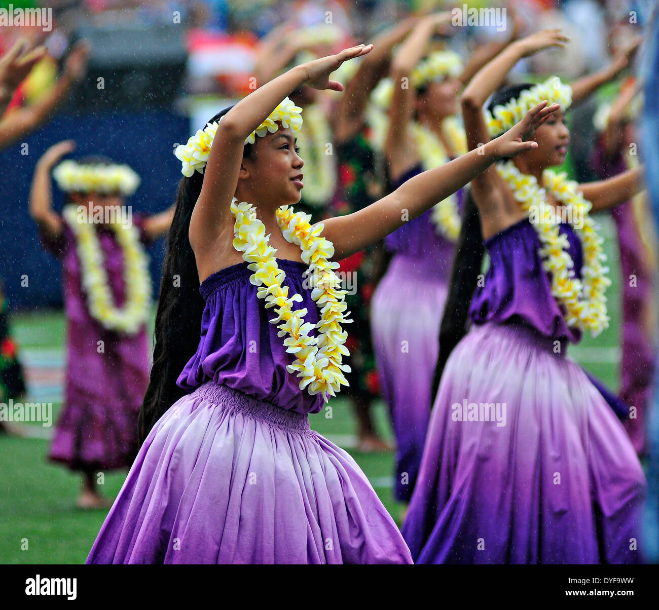 Traditional Hawaiian dancers perform Hula as a light rain falls January 17, 2013 in Honolulu, Hawaii. Stock Photo