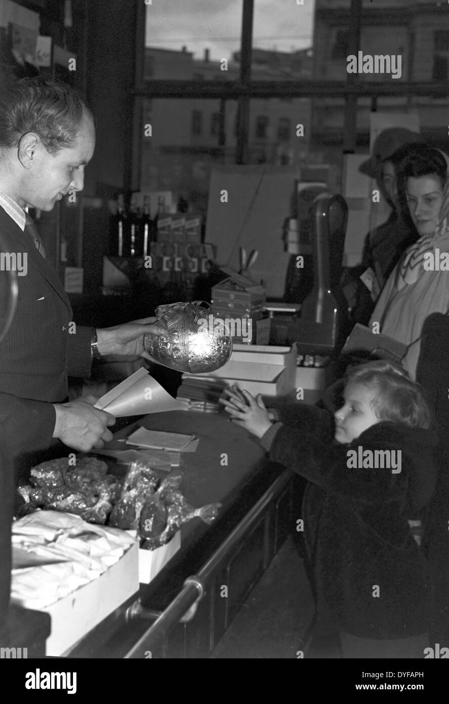 A girl receives a big glitter Easter egg in a store in Berlin in 1949. Stock Photo