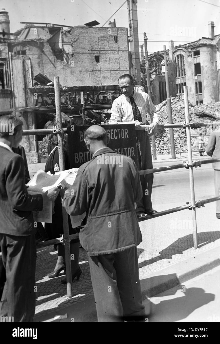 The end of the Berlin Blockade - West Berlin citizens are reading about the announced lifting of the Berlin Blockade in the daily news, at the border between the British and the Soviet Sector at Potsdam Square. Stock Photo