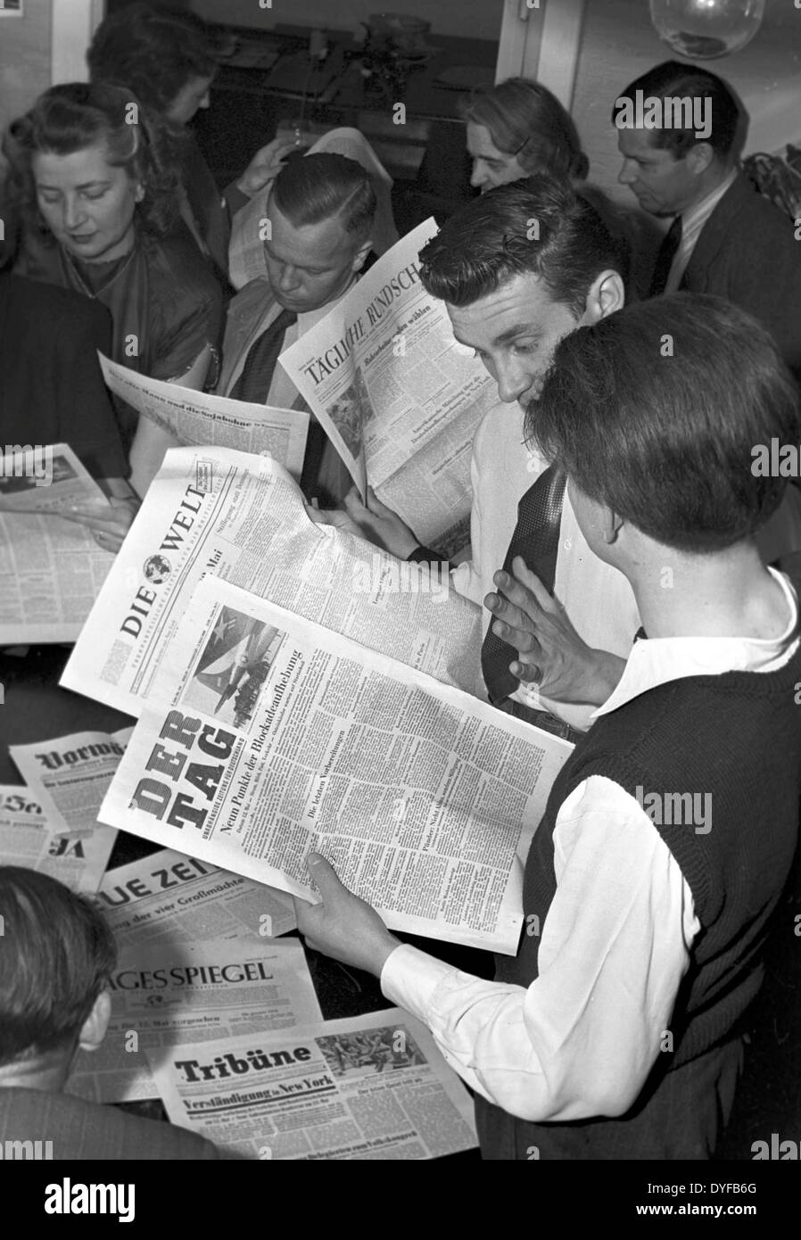 The end of the Berlin Blockade - Berlin citizens are reading about the announced lifting of the Berlin Blockade in the daily news. Stock Photo