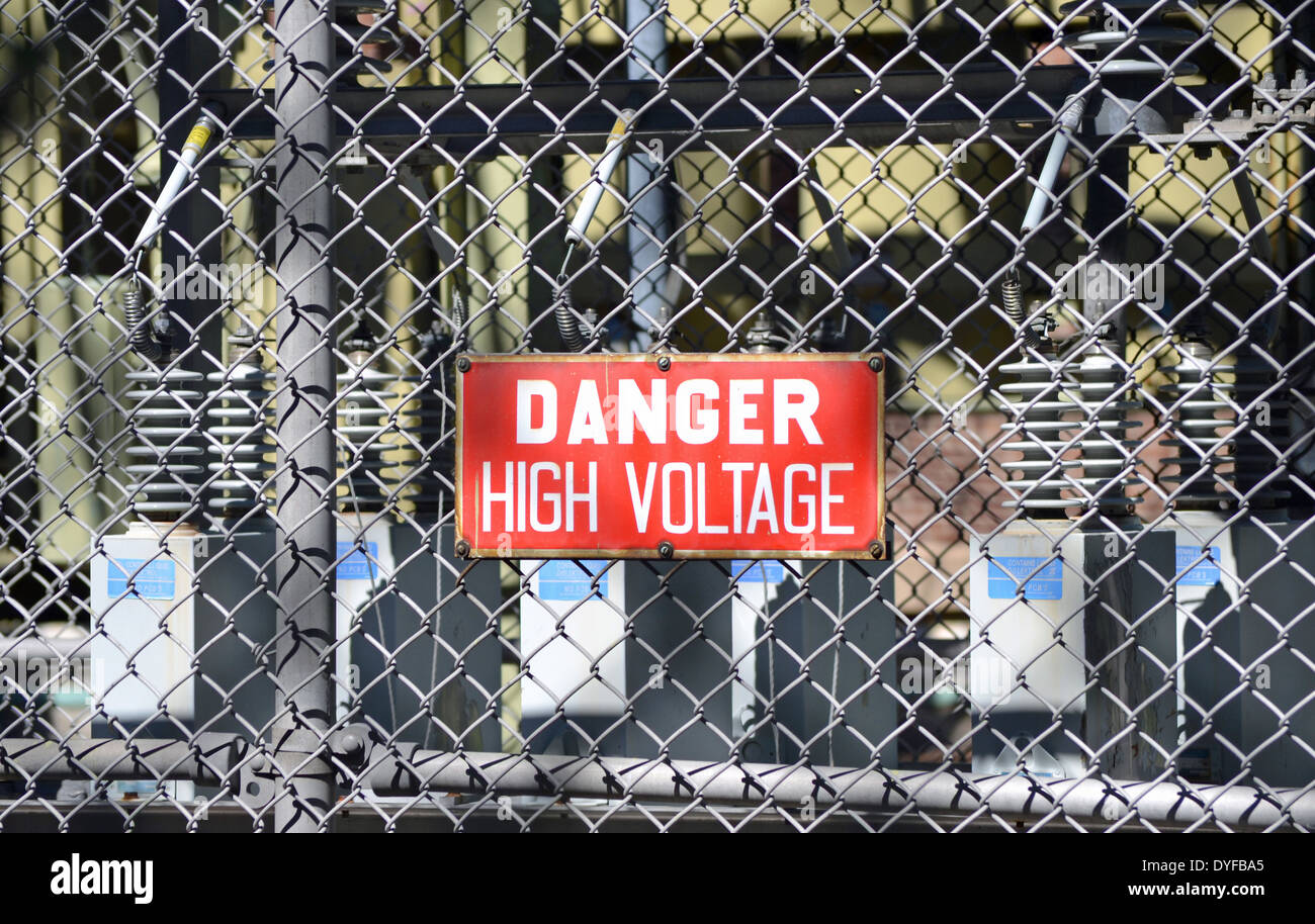 A red sign reading DANGER HIGH VOLTAGE at an electrical substation Stock Photo