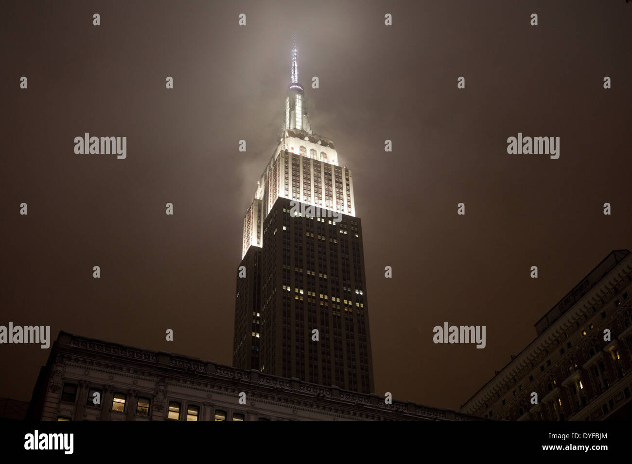 The art-deco architecture of New York's Empire State Building at night in a snowstorm Stock Photo