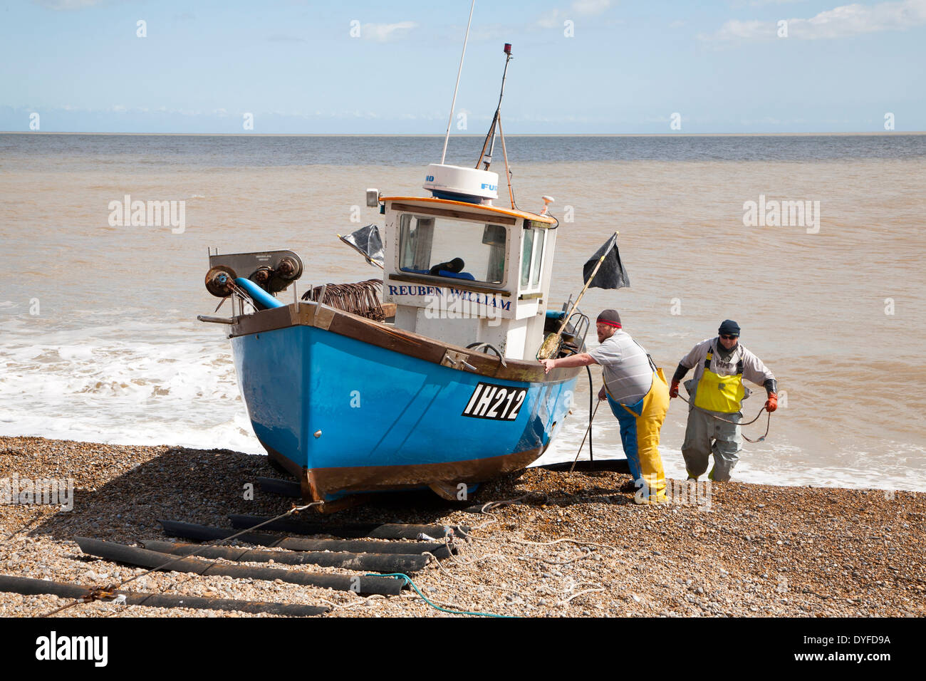 Small inshore fishing boat landing on the beach after six hours at sea