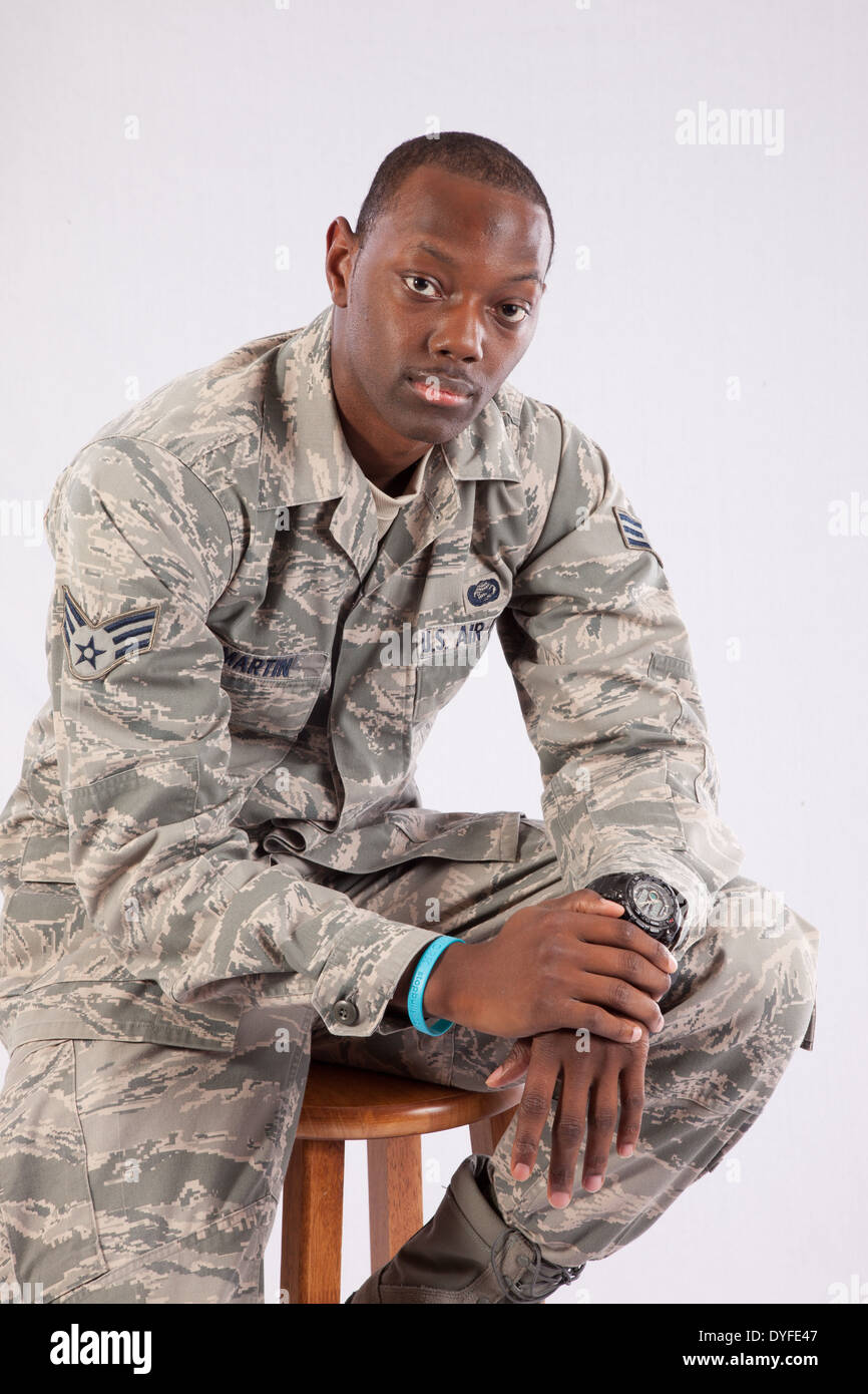 Black man in U.S. Air Force camouflage,fatigues, sitting on a wooden ...