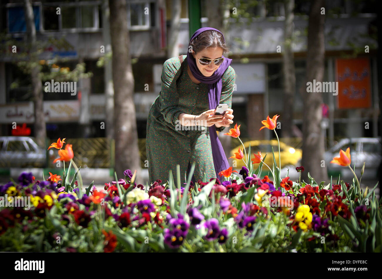 Tehran, Iran. 16th Apr, 2014. A woman takes pictures of flowers at a