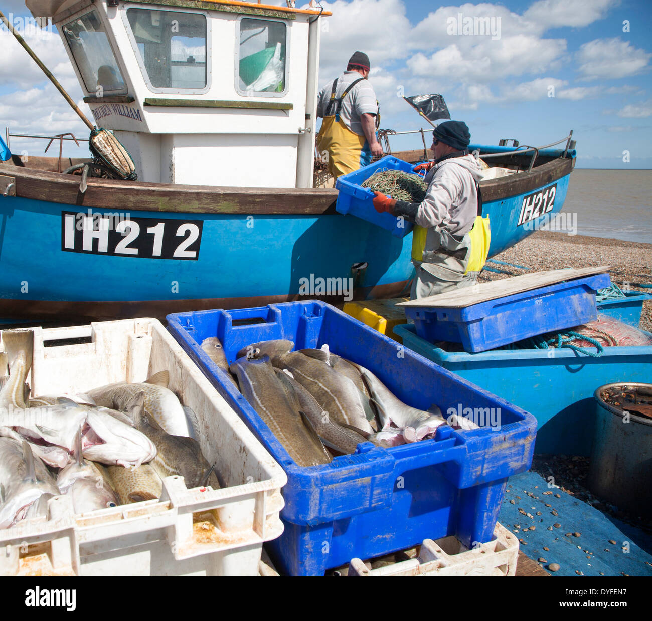 Small inshore fishing boat landing on the beach after six hours at sea