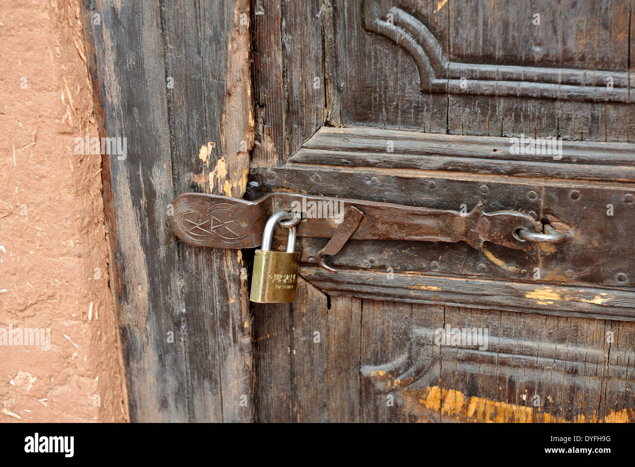Locked and closed metal lock on old weathered wooden door Stock Photo