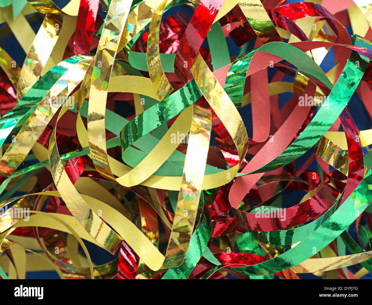 Closeup of twisted and tangled party streamers in red, green and golden color Stock Photo