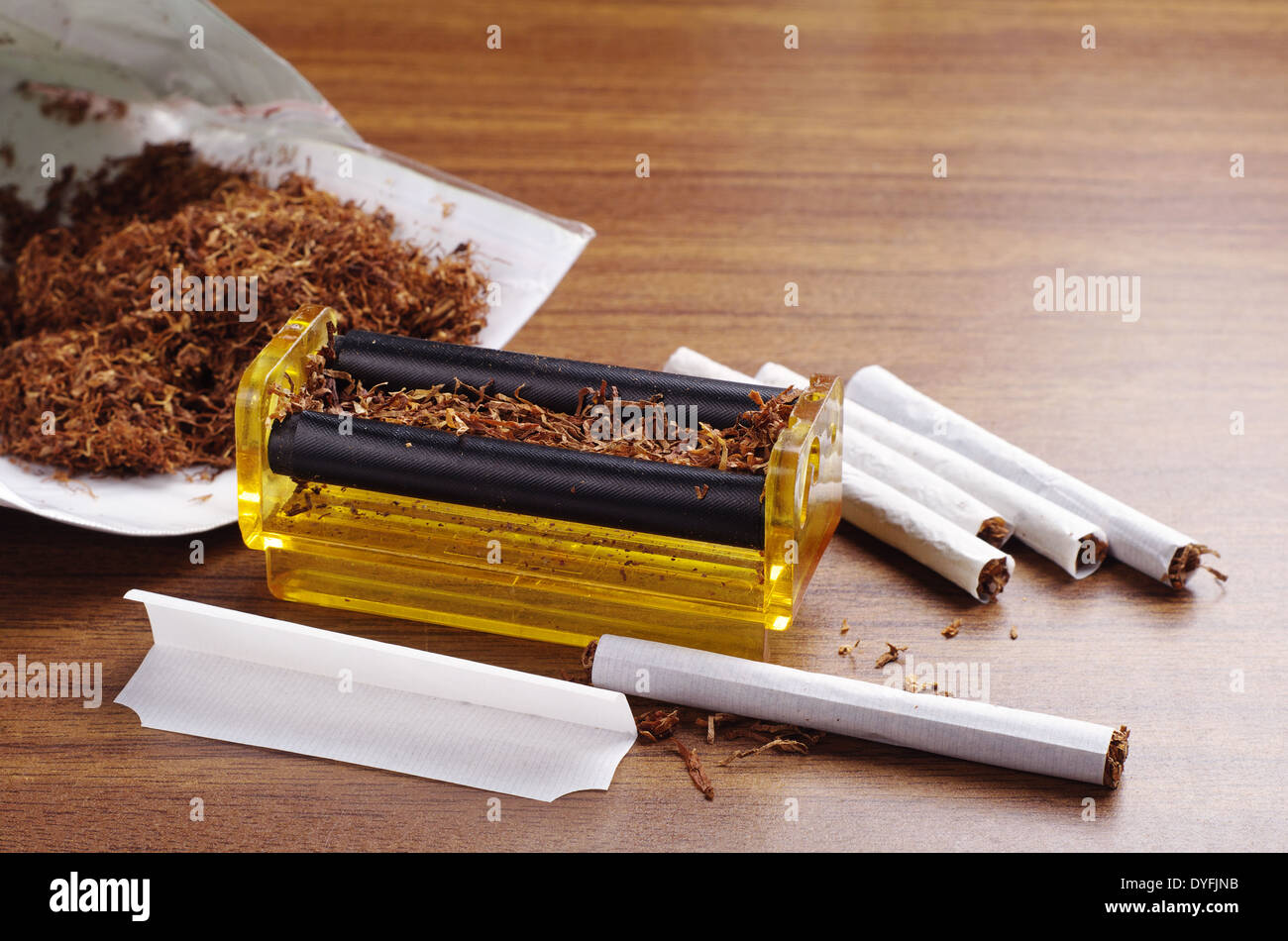 Rolling machine and cigarettes on brown table Stock Photo
