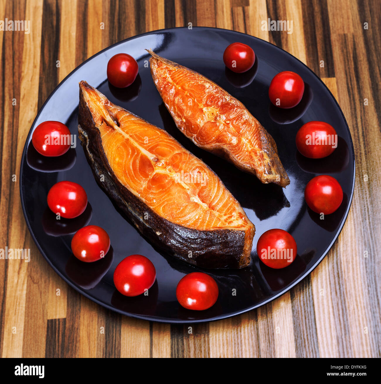 Smoked fish on plate with fresh tomatoes Stock Photo