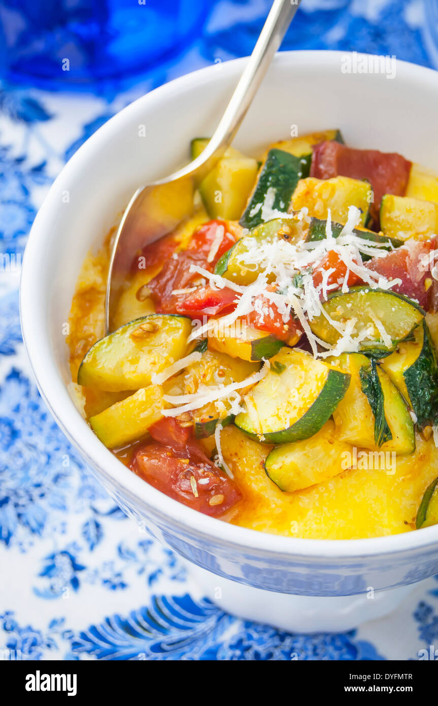 A Close Up View of a Bowl of Polenta with Zucchini Tomato Sauce Stock