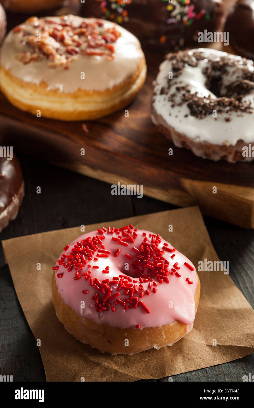 Assorted Homemade Gourmet Glazed Donuts on a Background Stock Photo