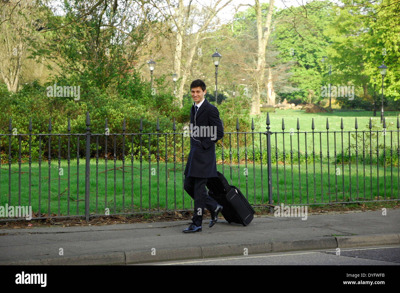 Smartly dressed man pulling luggage in Southampton, England Stock Photo