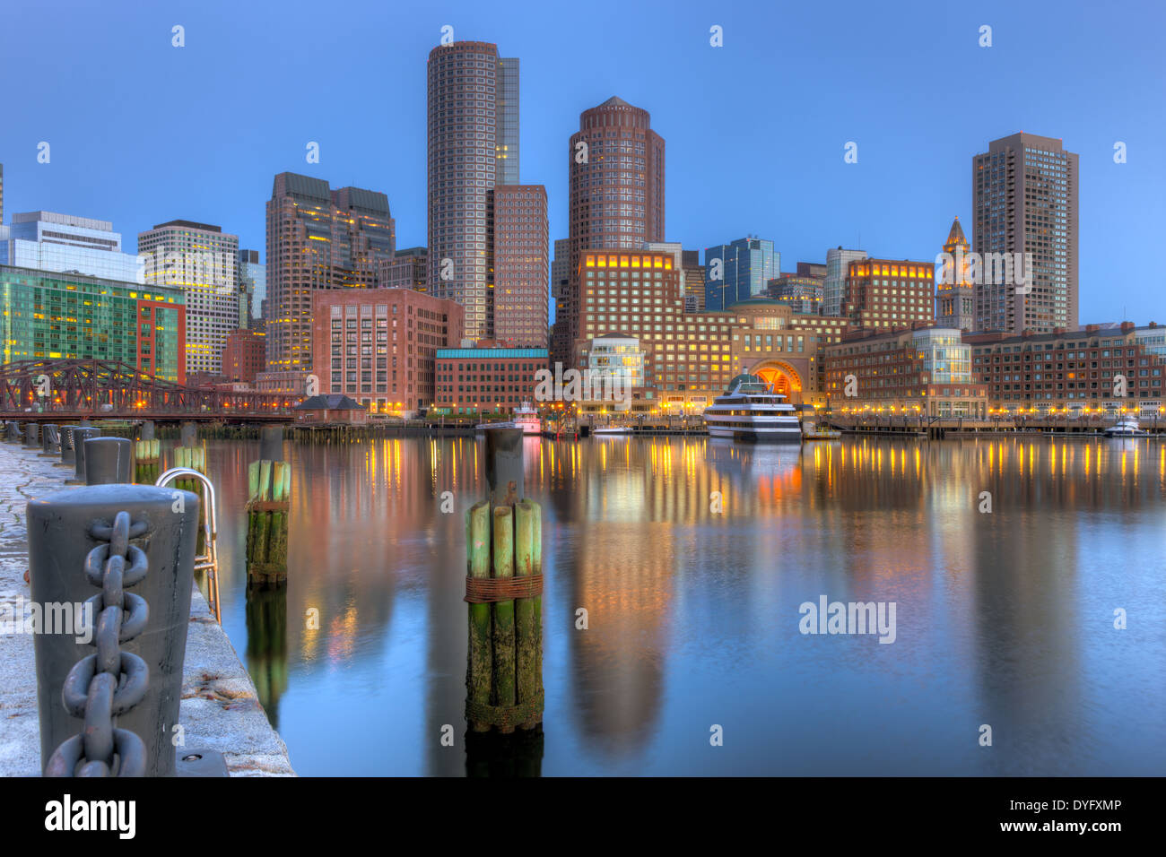The skyline reflects off the still waters of the harbor before sunrise as a new day begins in Boston, Massachusetts. Stock Photo