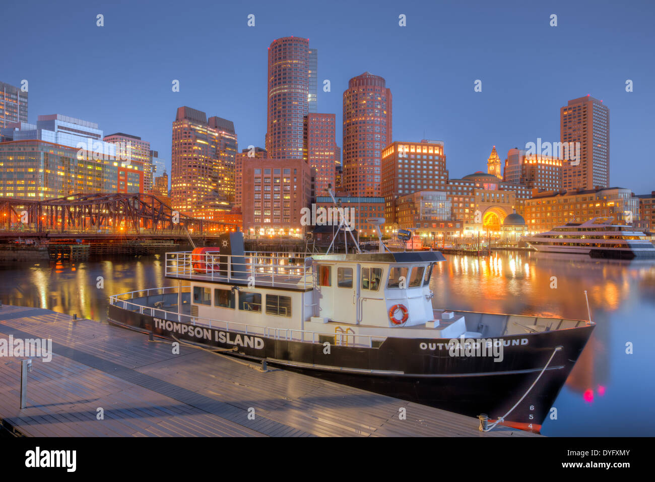 Outward Bound Thompson Island Ferry sits docked in front of the skyline before sunrise in Boston, Massachusetts. Stock Photo