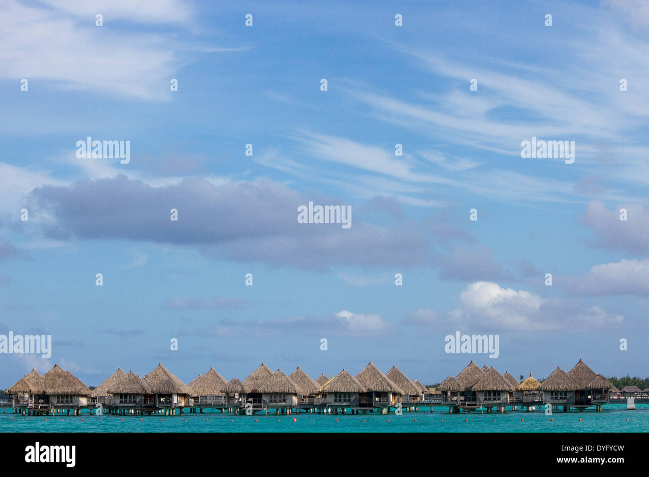 Overwater bungalows with big sky and turquoise water in Bora Bora, French Polynesia Stock Photo