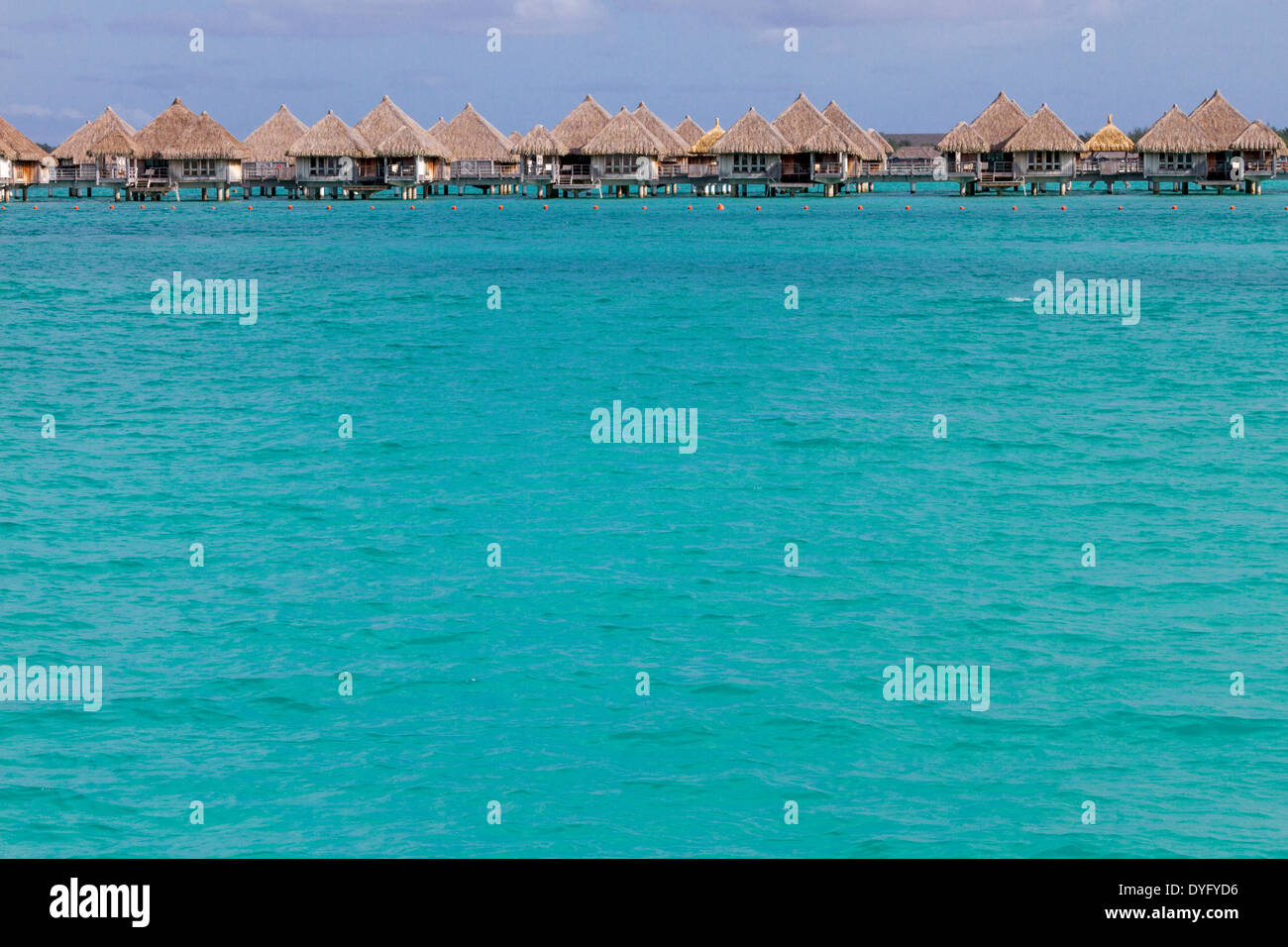 Overwater bungalows over turquoise water in Bora Bora in French Polynesia Stock Photo