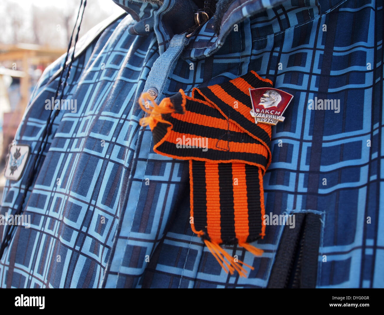 Luhansk, Ukraine. 17th April, 2014. pro-Russian activist attached to his jacket St. George ribbon using Komsomol badge near the Ukrainian regional office of the Security Service in Luhansk Credit:  Igor Golovnov/Alamy Live News Stock Photo