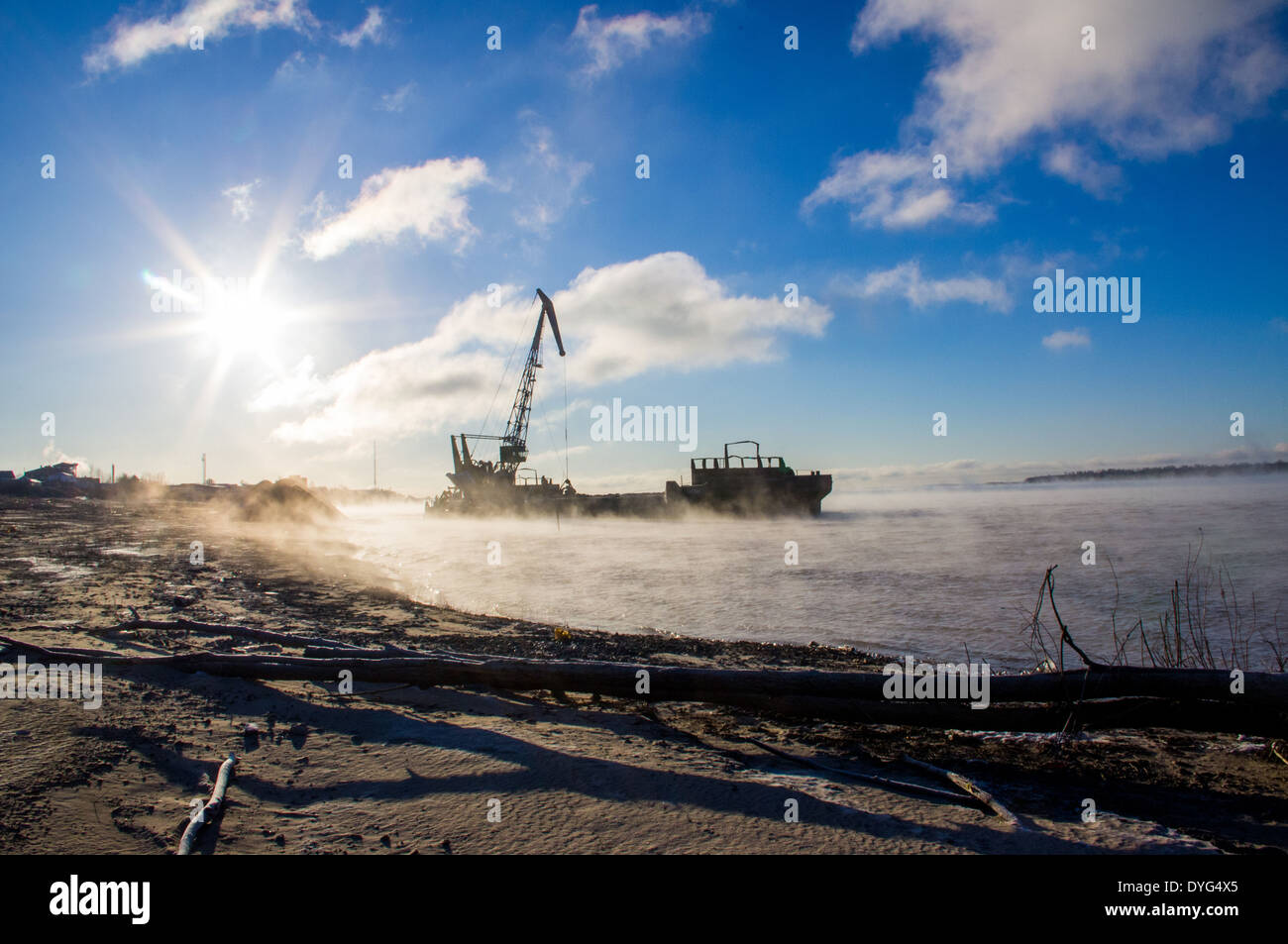 Floating crane barge unloads sand, gravel Stock Photo