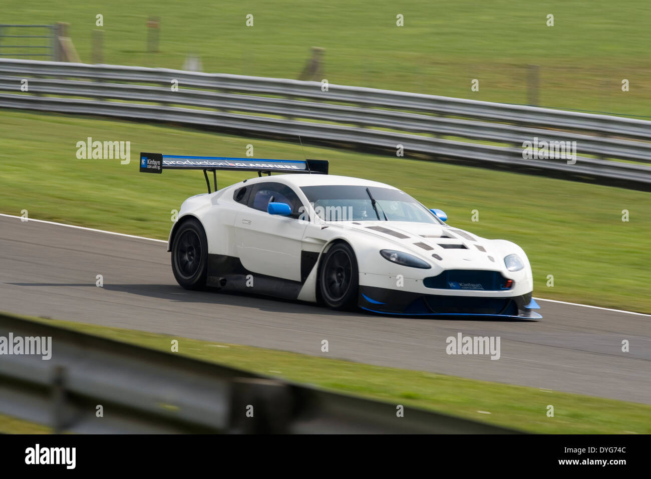 Aston Martin GT3 speeding along a straight at Oulton Park race circuit. Stock Photo
